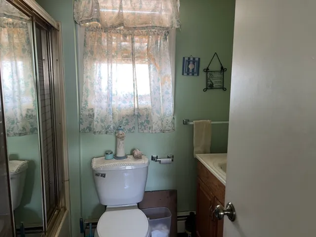 a bathroom with a toilet a sink and mirror