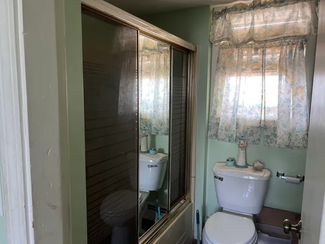 a bathroom with a toilet and a shower
