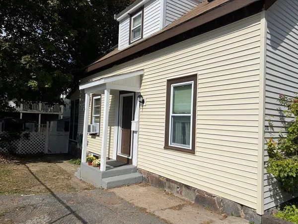 a view of a house with entryway and a yard