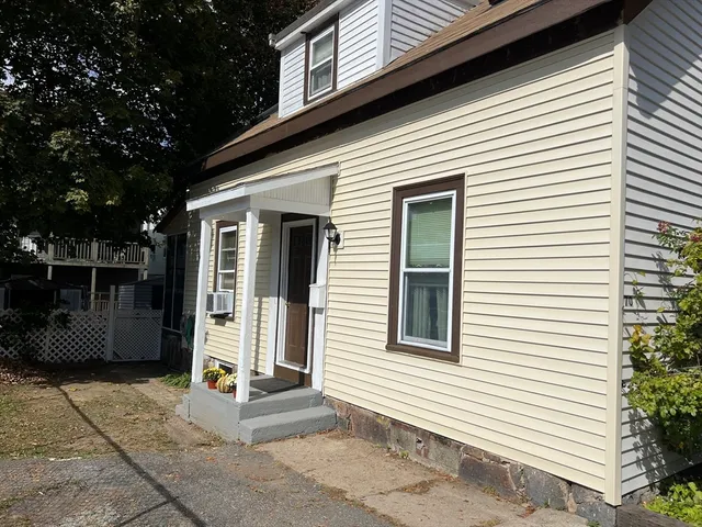 a view of a house with entryway and a yard