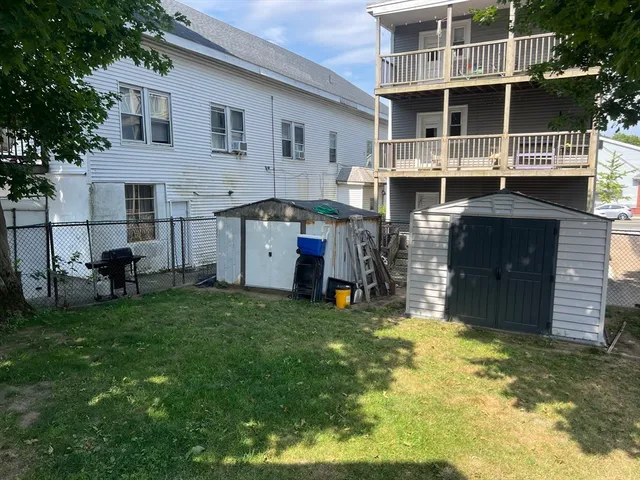 a view of a house with a yard and sitting area