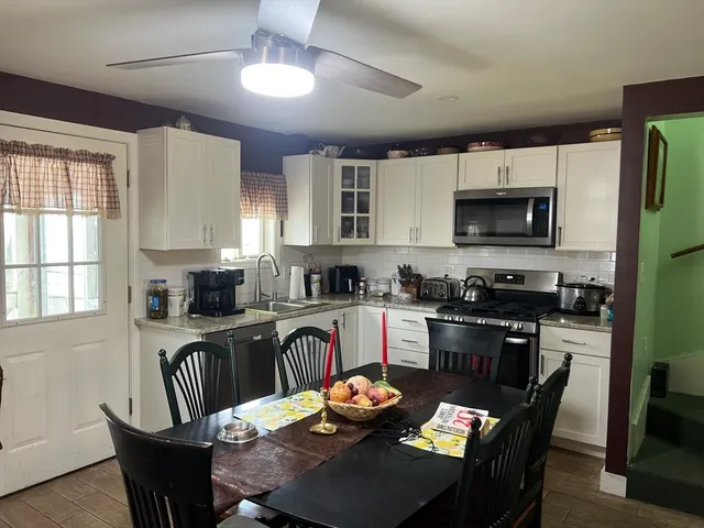 a kitchen with granite countertop a dining table and chairs