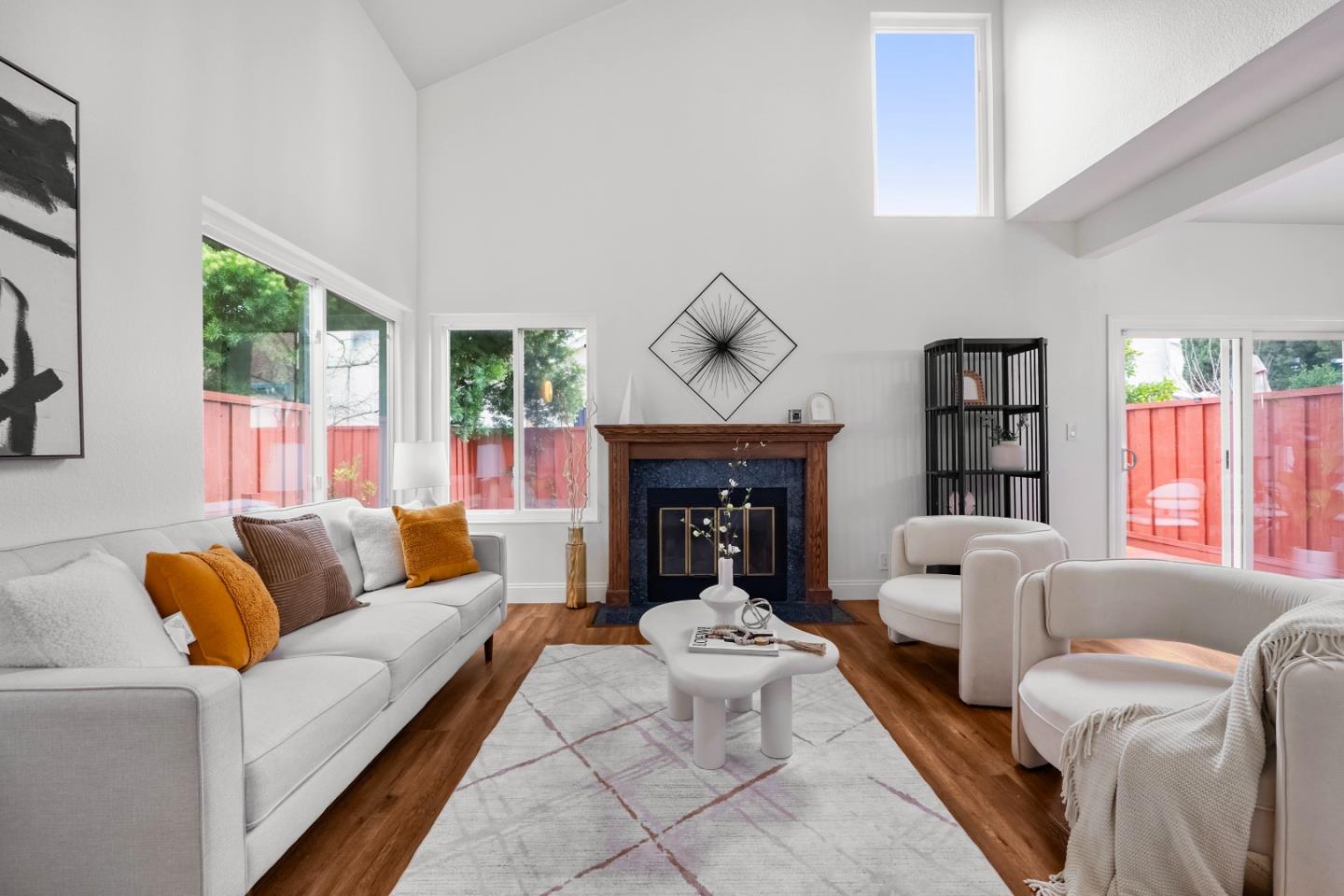 a living room with furniture a fireplace and a large window