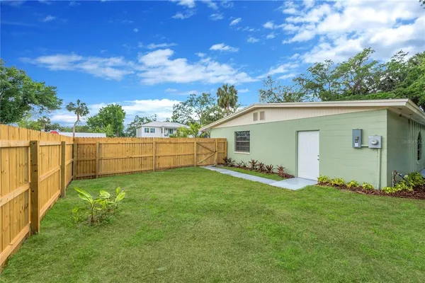 a view of a backyard with potted plants and wooden fence