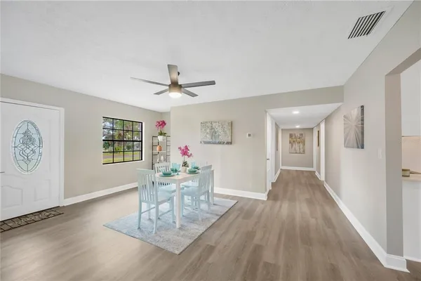 a living room with furniture and a wooden floor