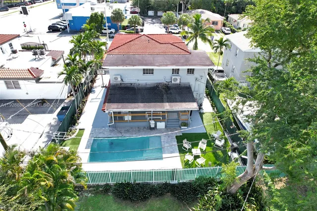 a view of a house with a yard and palm trees