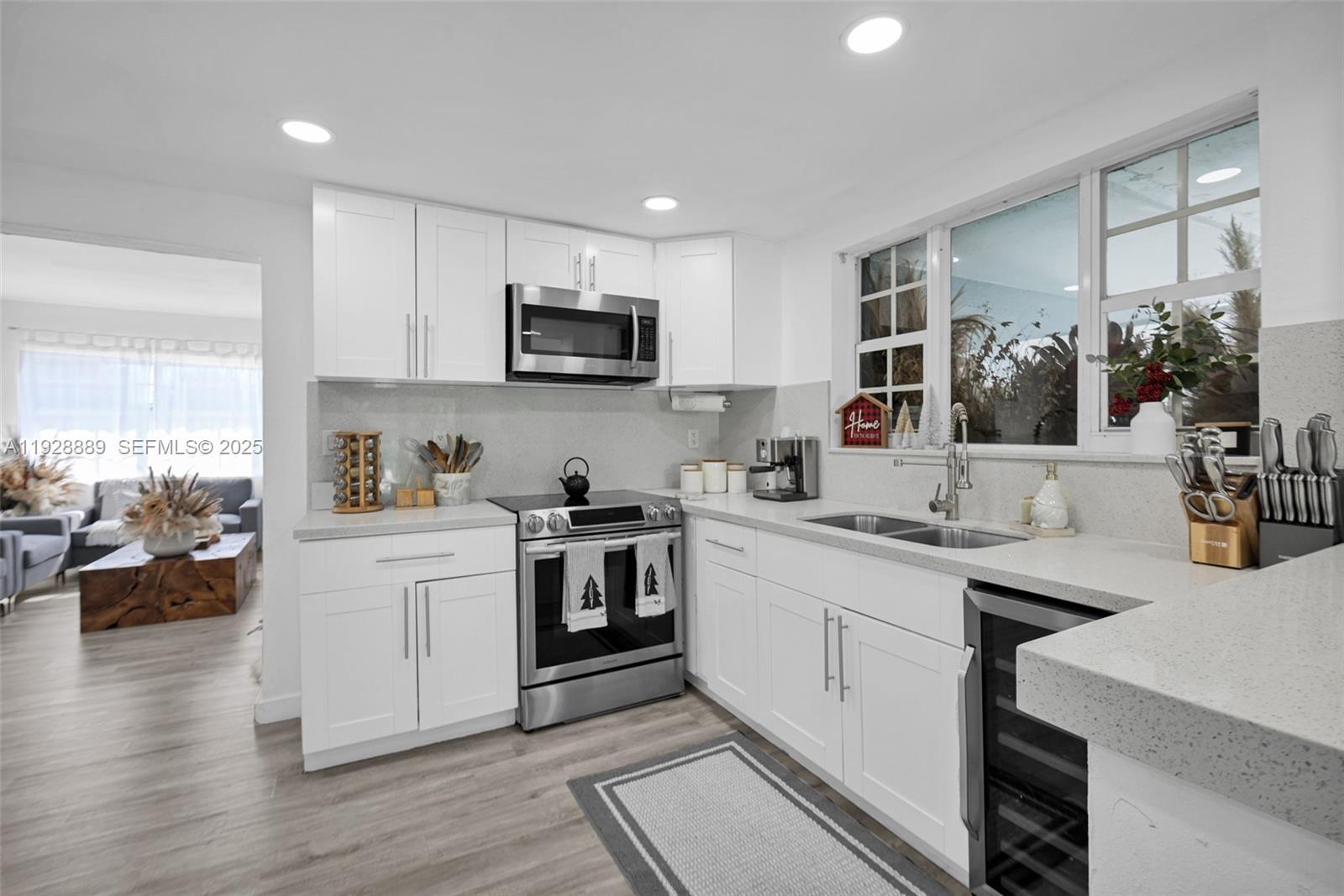 3711 Southwest 27th Terrace Miami, FL 33134 - Photo 21 of 62 a kitchen with stainless steel appliances white cabinets a sink a stove a window and wooden floor