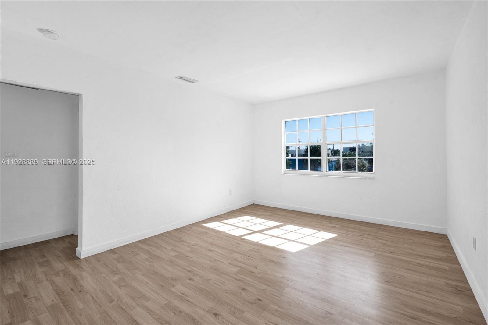 3711 Southwest 27th Terrace Miami, FL 33134 - Photo 47 of 62 a view of an empty room with window and wooden floor