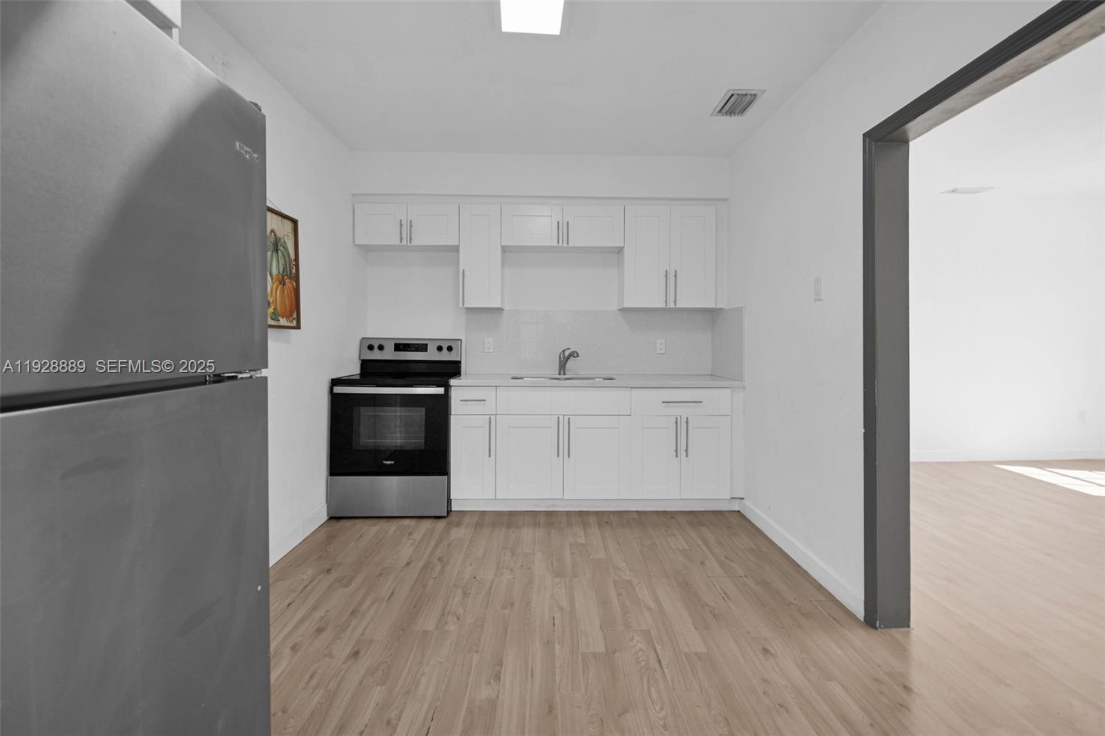 3711 Southwest 27th Terrace Miami, FL 33134 - Photo 55 of 62 a kitchen with white cabinets and wooden floor
