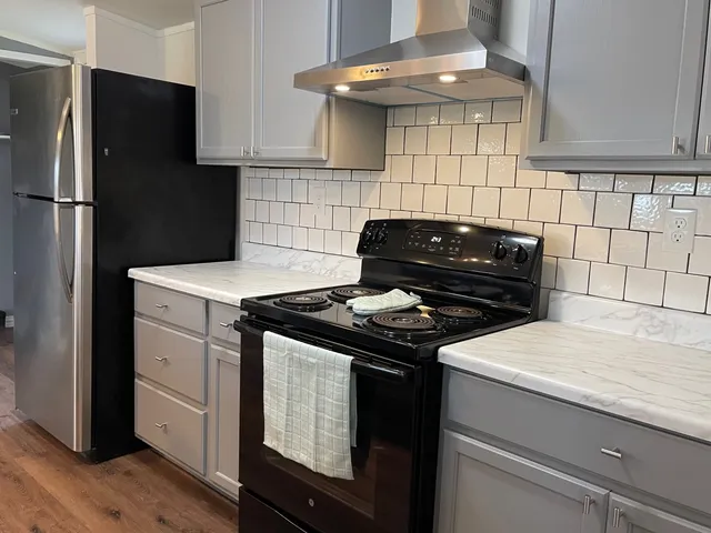 a kitchen with a stove cabinets and wooden floor