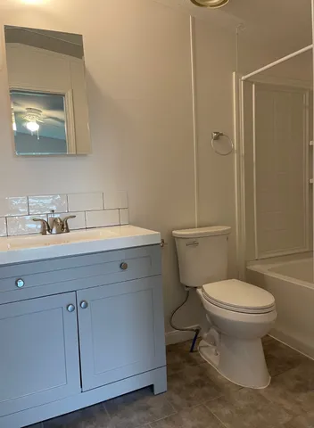 a bathroom with a sink toilet and mirror