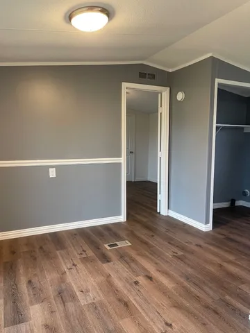 an empty room with wooden floor and closet