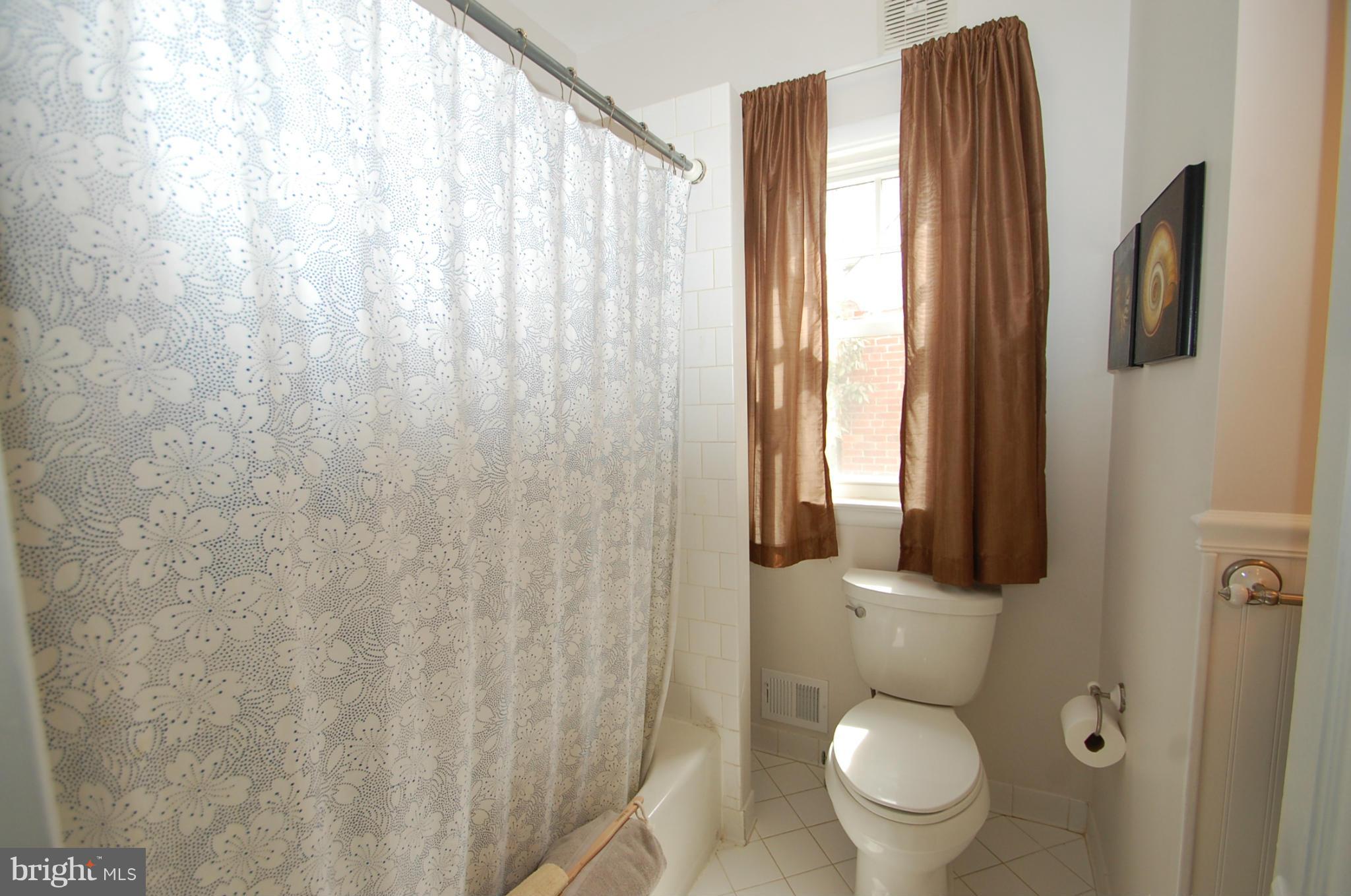 2104 Hanover Street Silver Spring, MD 20910 - Photo 13 of 22 a white toilet sitting next to a shower curtain