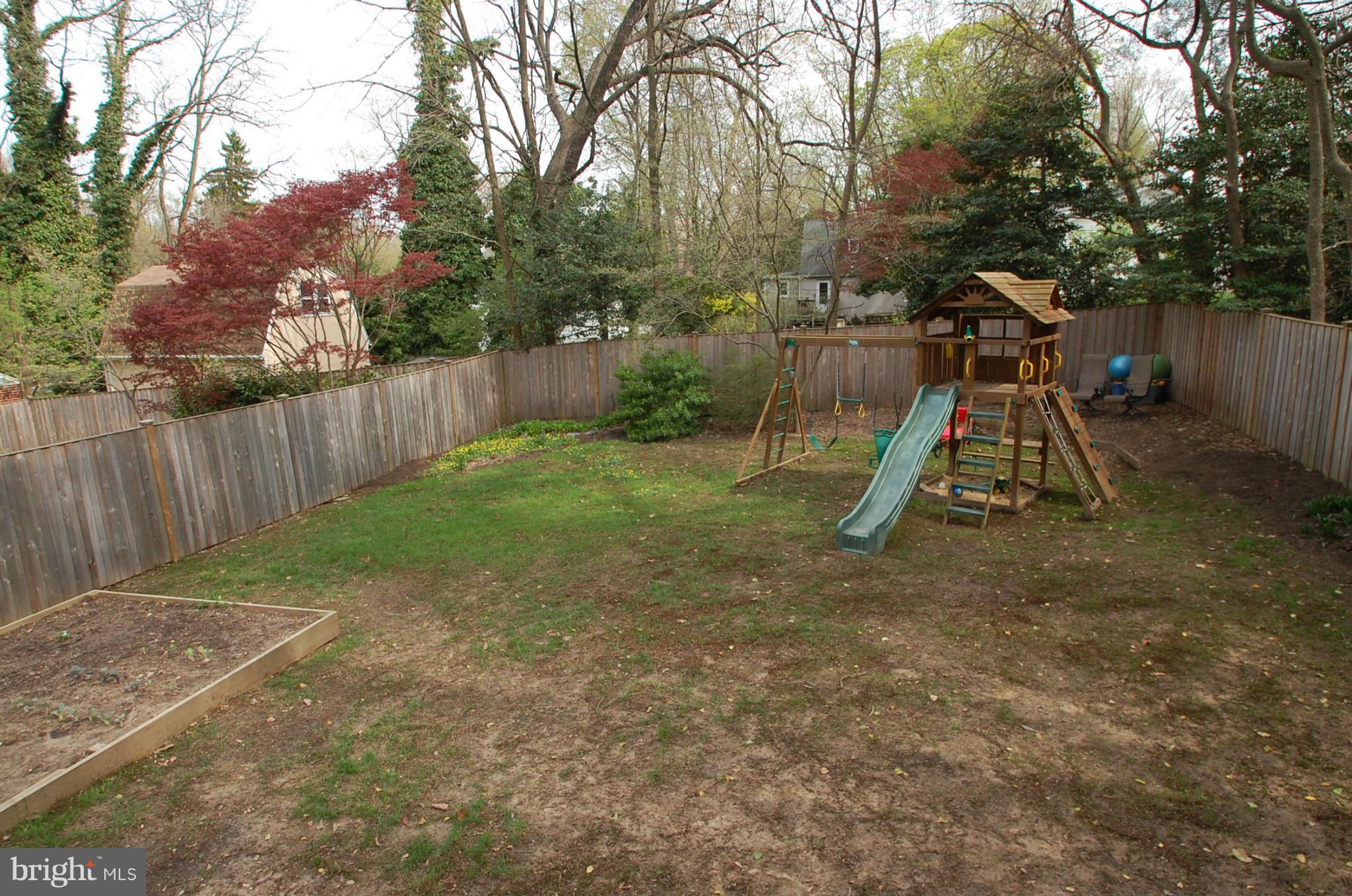 2104 Hanover Street Silver Spring, MD 20910 - Photo 17 of 22 a view of a backyard with a slide trees and wooden fence