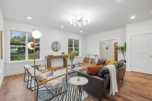 a kitchen with stainless steel appliances granite countertop a refrigerator a sink dishwasher a stove and white cabinets with wooden floor