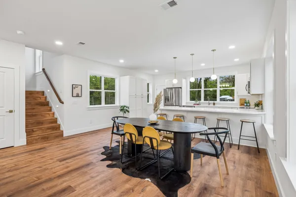 a large kitchen with stainless steel appliances a stove a sink and a refrigerator