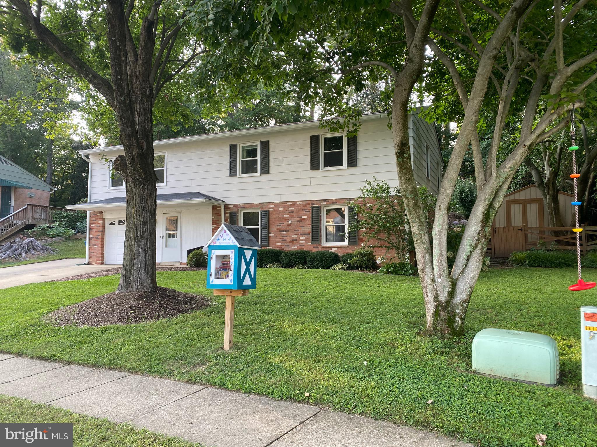a front view of a house with a yard and tree