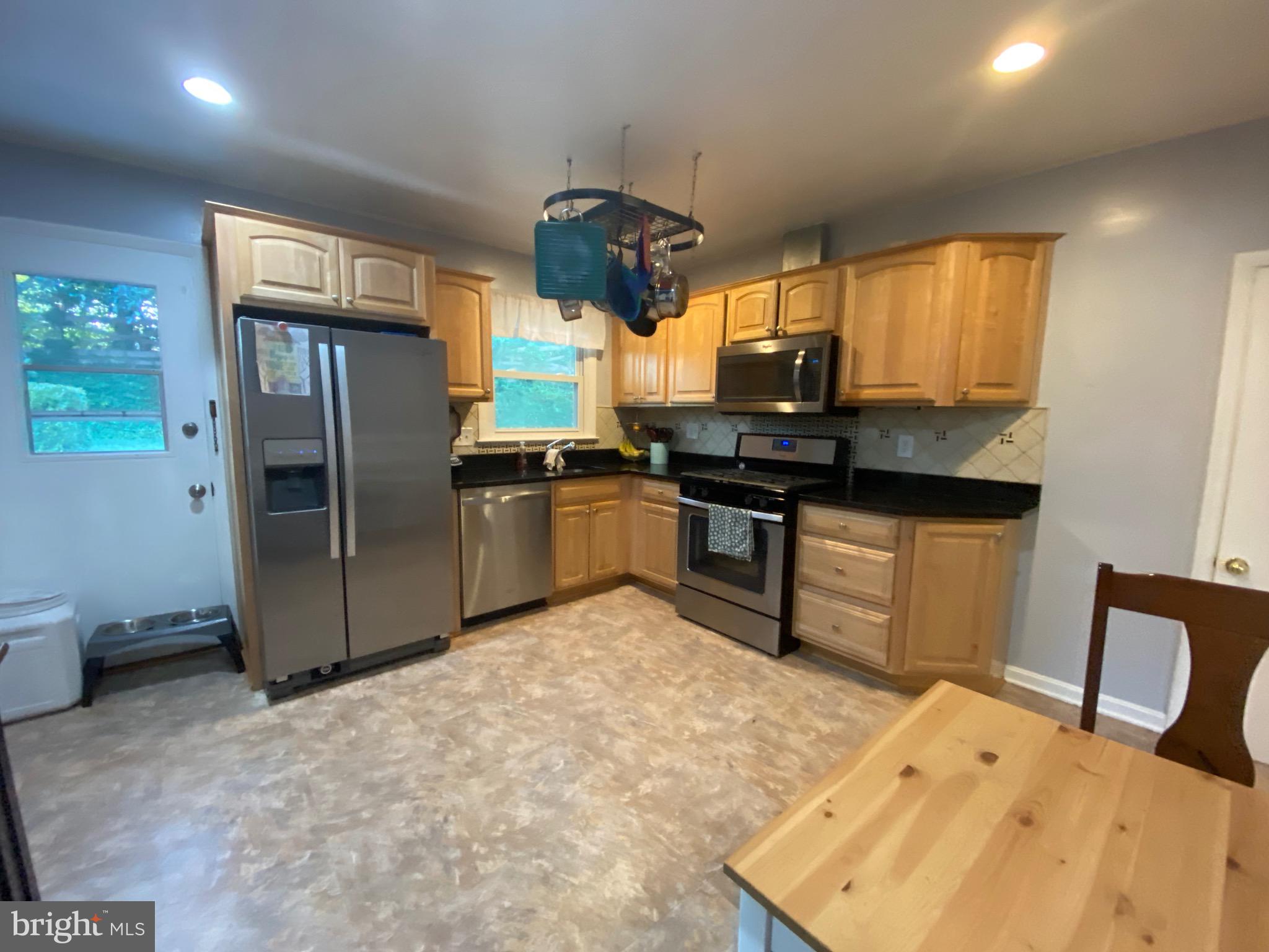 8614 Arley Drive Springfield, VA 22152 - Photo 7 of 24 a kitchen with stainless steel appliances granite countertop a sink stove and refrigerator