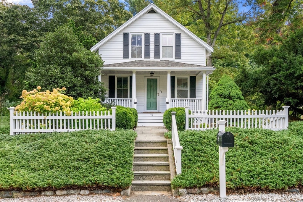 a front view of a house with a garden and plants