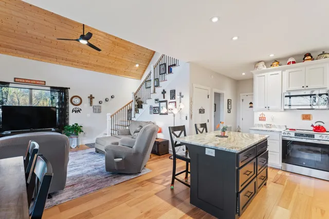 a utility room with fridge and wooden floor