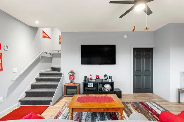 a living room with furniture a flat screen tv and a chandelier