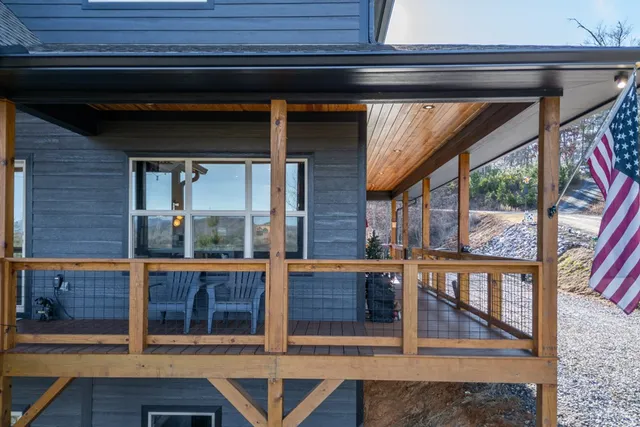 a front view of a house with yard and trees in the background