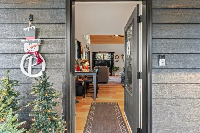 a living room with furniture and a dining table with wooden floor