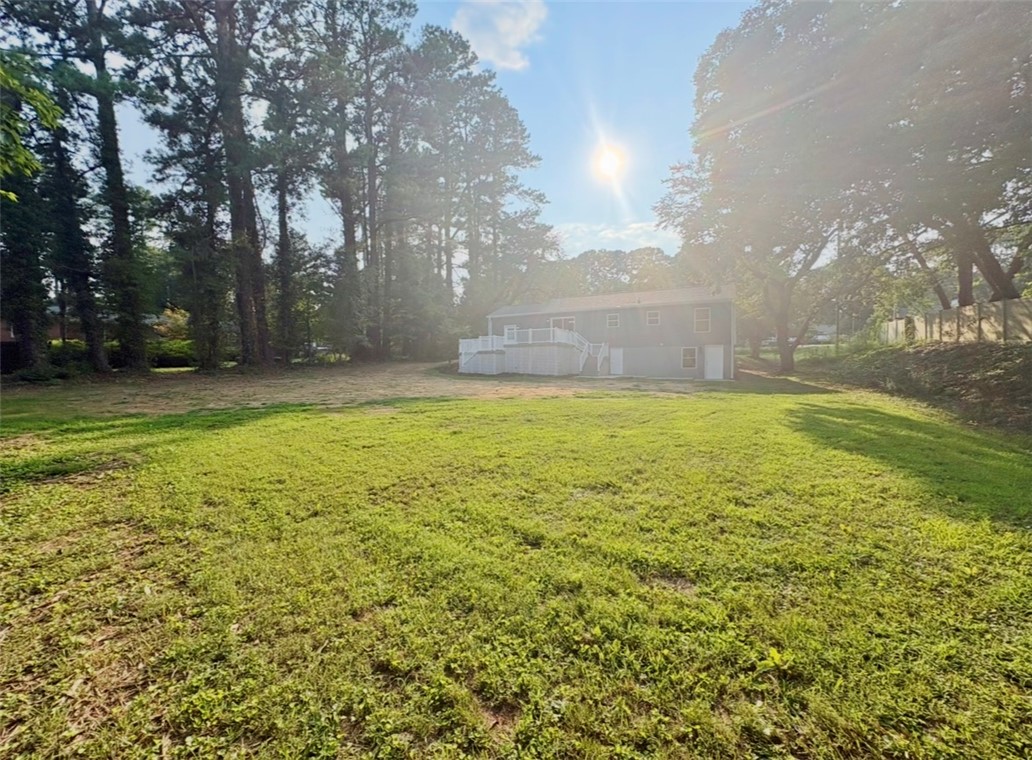 1904 East Calhoun Street Anderson, SC 29621 - Photo 34 of 36 A verdant backyard with mature trees and a spacious deck, perfect for outdoor enjoyment.