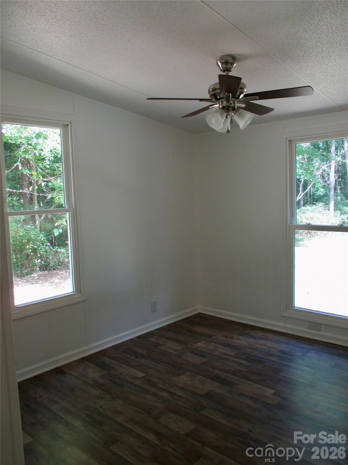 5714 Tipton Road Monroe, NC 28112 - Photo 17 of 26 an empty room with wooden floor fan and windows