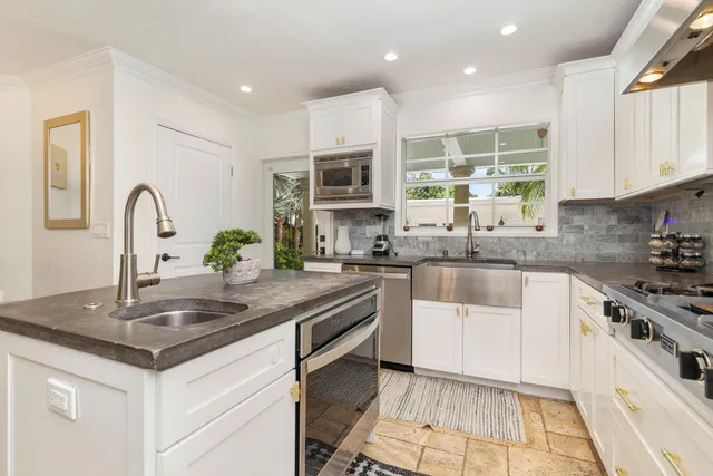 a kitchen with stainless steel appliances granite countertop a sink a stove a microwave a counter space and cabinets