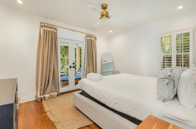 a bedroom with a bed and a large mirror on the dresser