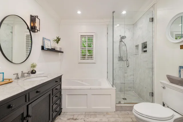 a bathroom with a double vanity sink toilet mirror and shower