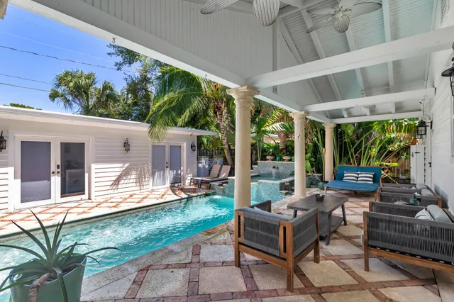 a view of a patio with couches table and chairs with wooden floor and fence