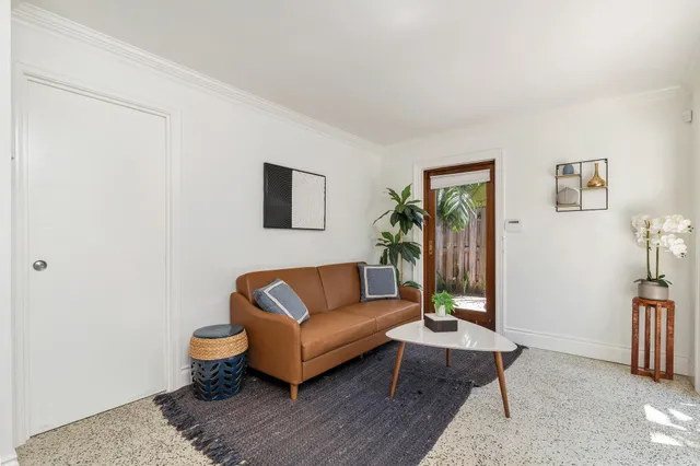 a living room with furniture wooden floor and a window