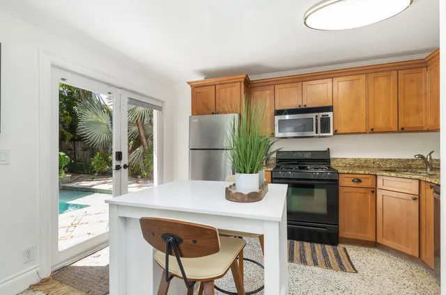 a kitchen with a refrigerator and a stove top oven