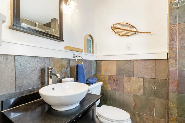 a bathroom with a sink mirror vanity and toilet