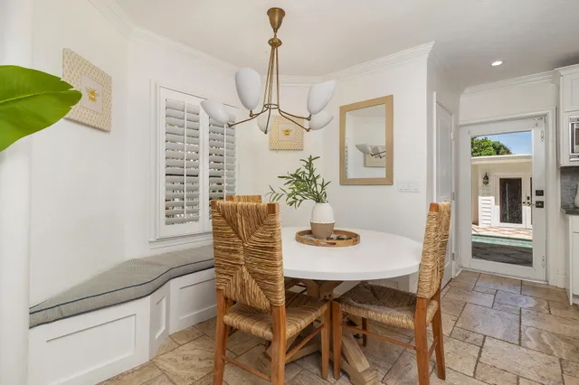 a dining room with furniture a chandelier and window