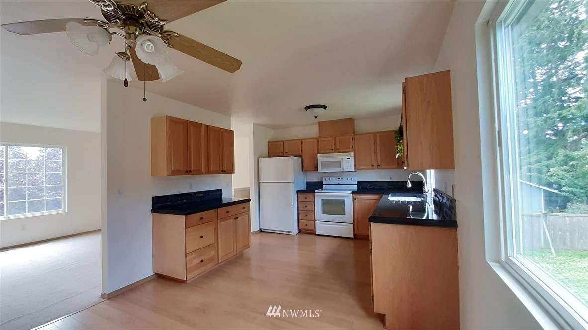 333 East Springfield Loop Shelton, WA 98584 - Photo 8 of 27 a kitchen with stainless steel appliances a stove a refrigerator a sink a oven with wooden cabinets and wooden floor