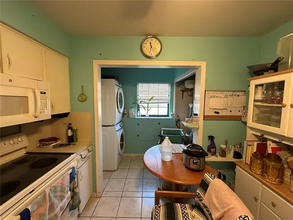a kitchen with a stove a table and chairs in it