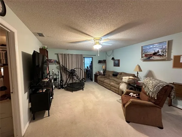 a living room with furniture gym equipment and a flat screen tv
