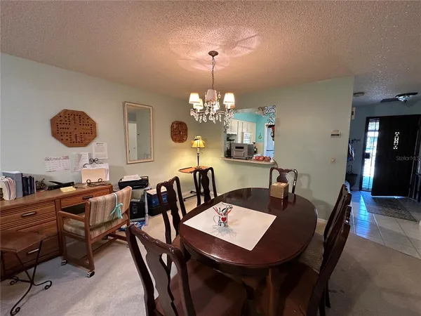 a view of a dining room with furniture and chandelier