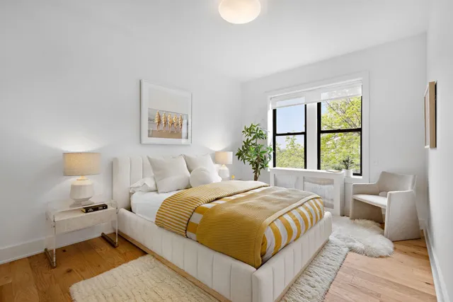 a bedroom with a bed and a potted plant