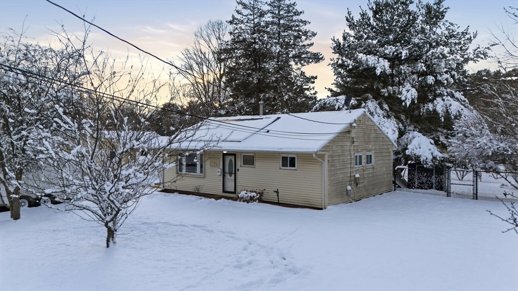 a view of a house with a large tree and a yard