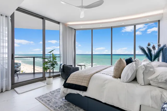 a bedroom with a large window and a bed