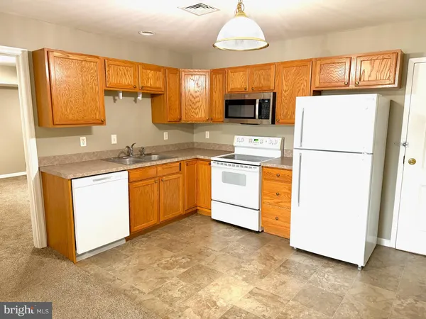 a kitchen with stainless steel appliances granite countertop a refrigerator a sink dishwasher a microwave oven with cabinets and wooden floor