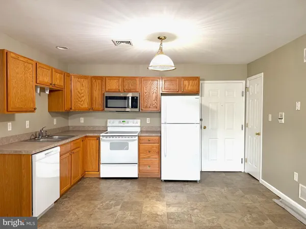 a kitchen with stainless steel appliances granite countertop a refrigerator a stove a sink and a microwave
