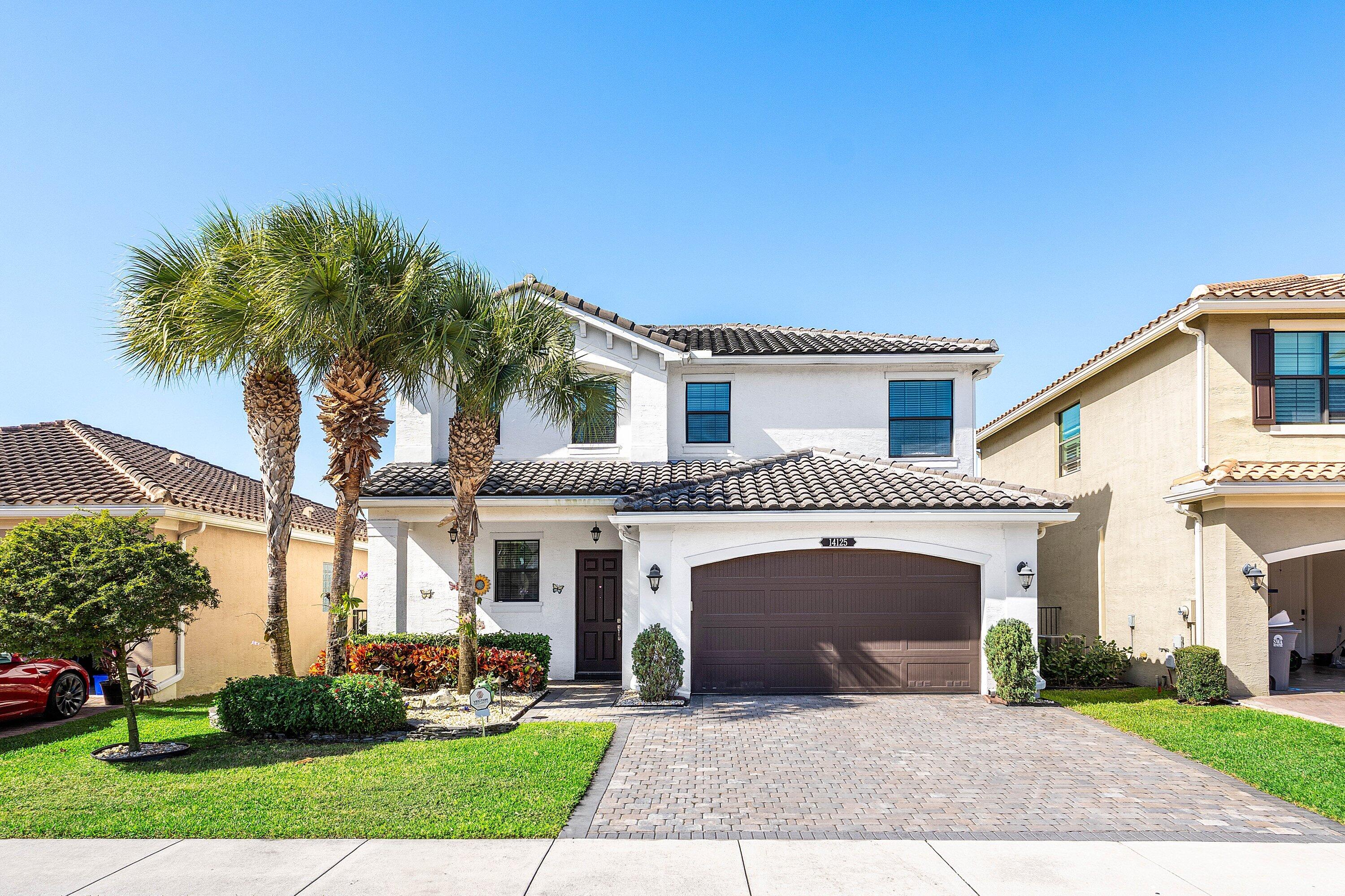14125 Rock Salt Road Delray Beach, FL 33446 - Photo 1 of 55 a front view of a house with a garden and palm trees