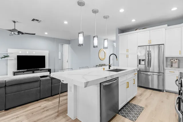 a view of kitchen with stainless steel appliances kitchen island a sink and a refrigerator