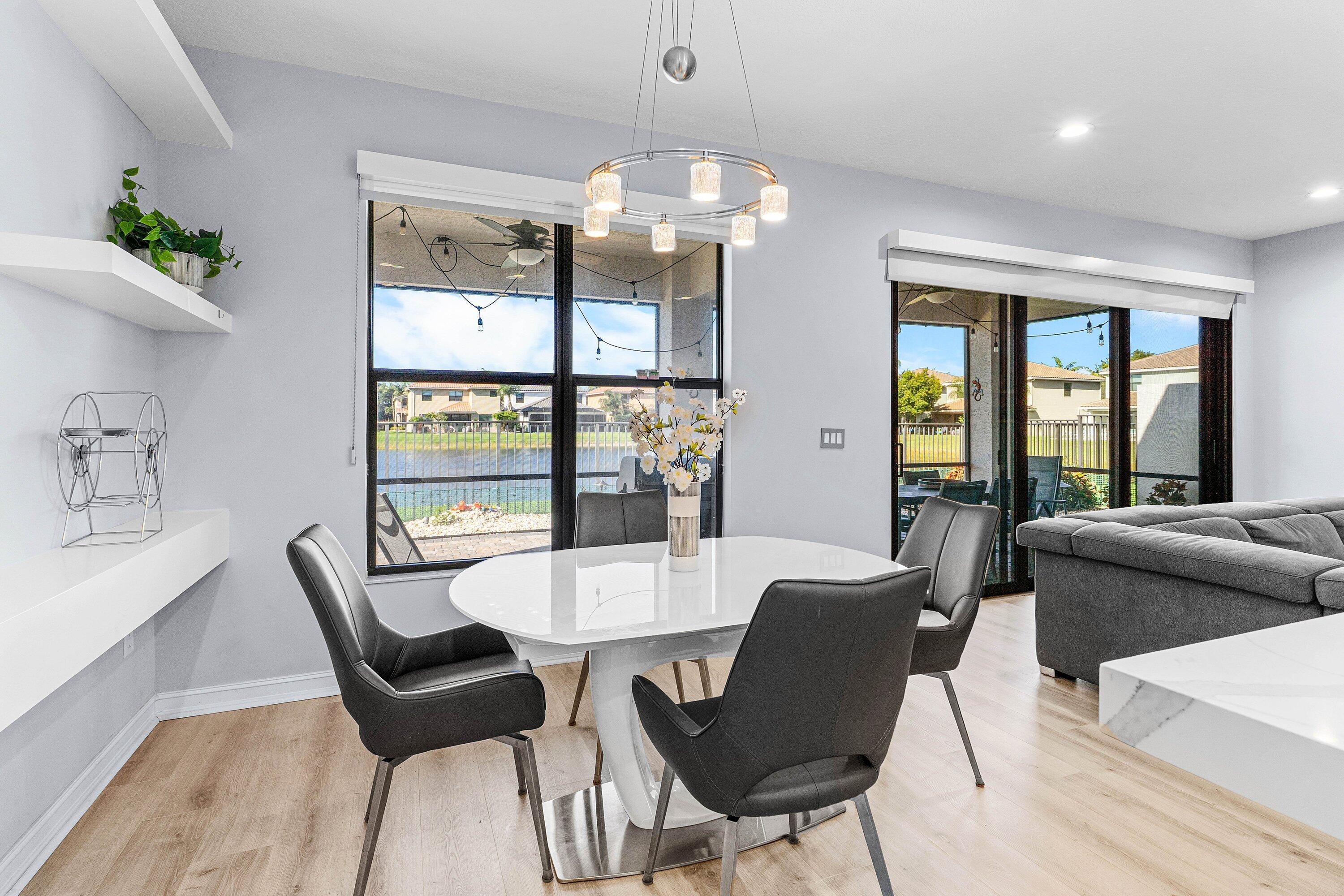 14125 Rock Salt Road Delray Beach, FL 33446 - Photo 13 of 55 a view of a dining room with furniture large windows and wooden floor