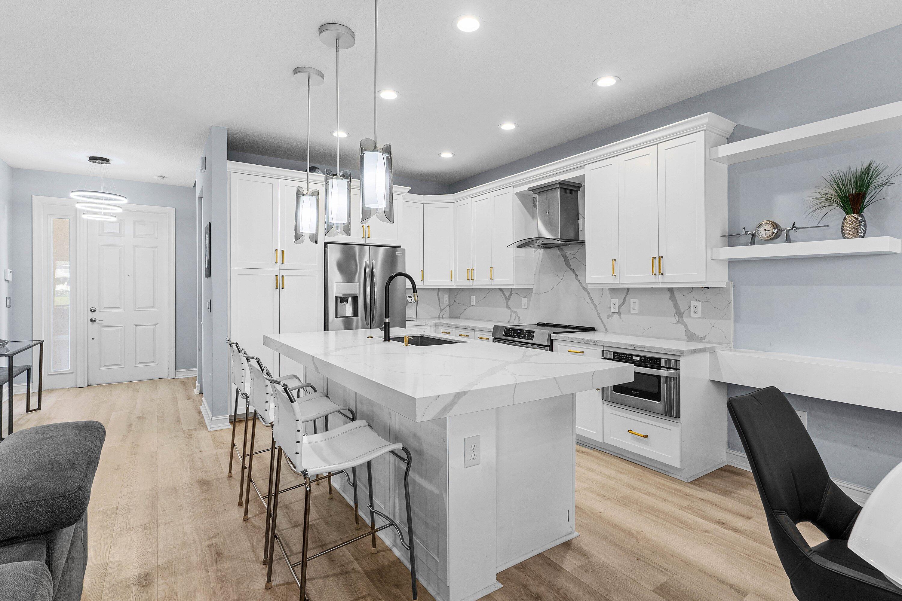 14125 Rock Salt Road Delray Beach, FL 33446 - Photo 10 of 55 a kitchen with kitchen island stainless steel appliances a table chairs sink and cabinets